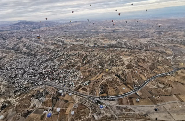 Dozens of hot air balloons over the valleys of Cappadocia, seen from a balloon